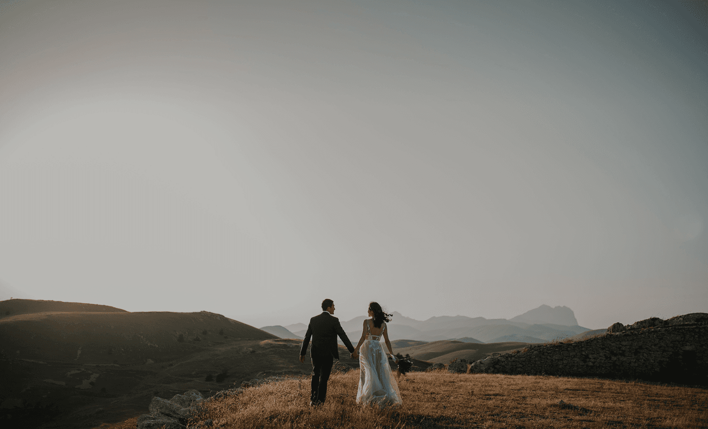 Couple walking through the Italian countryside at sunset
